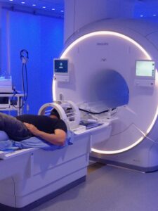 Person lies in MRI machine while concurrently receiving rTMS treatment for depression.